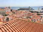 Widok z jednego z tarasów widokowych na dachy Lizbony i najdłuższe w Europie nabrzeże portowe (do którego właśnie przybiły 3 ogromne statki pasażerskie).